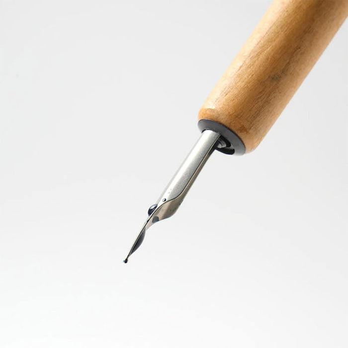 Wooden dip pen with nib on white background