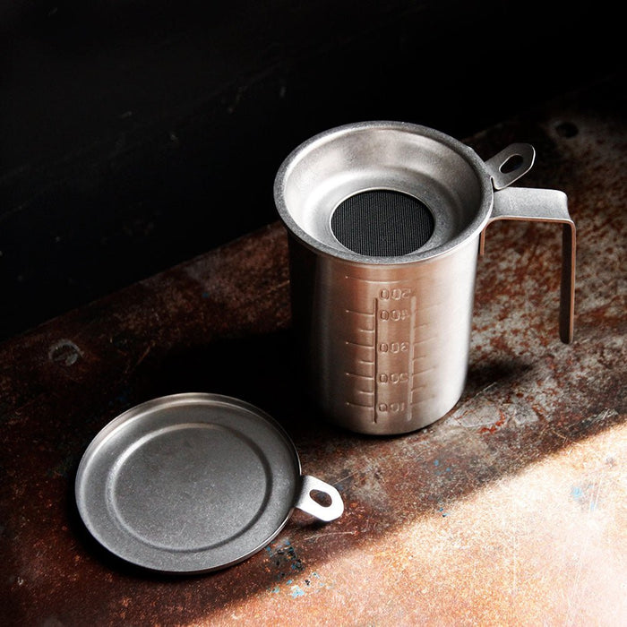 Metal measuring cup with lid on a rustic surface
