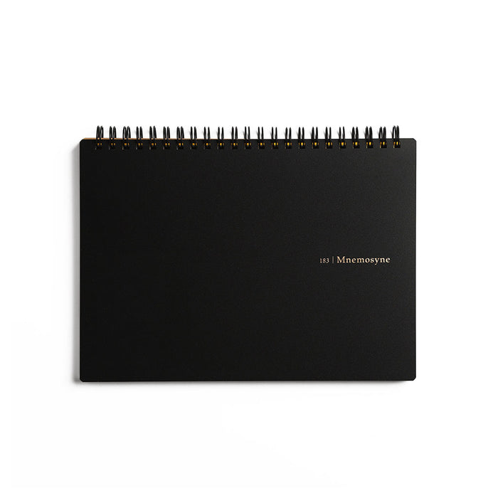 A black spiral-bound notebook with gold foil text reading '183 | Mnemosyne' on the cover.
