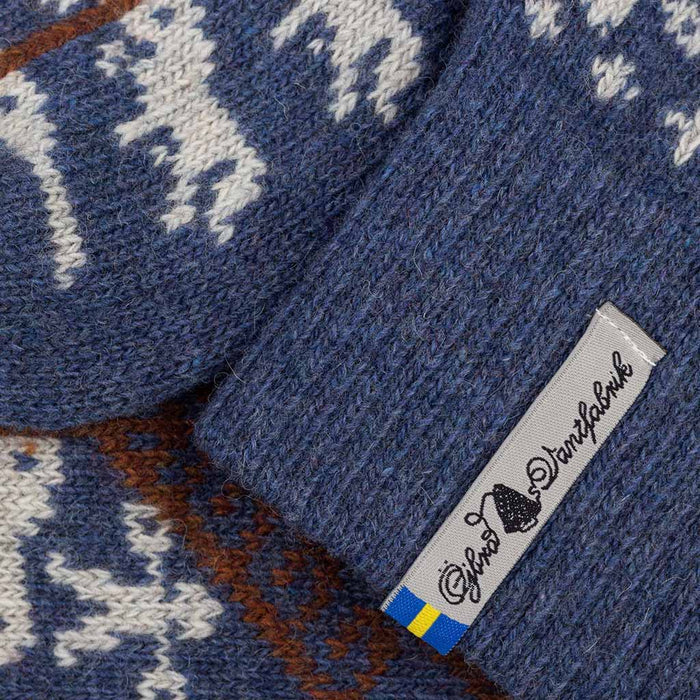 Close-up of a blue knitted fabric with a pattern and a brand label.